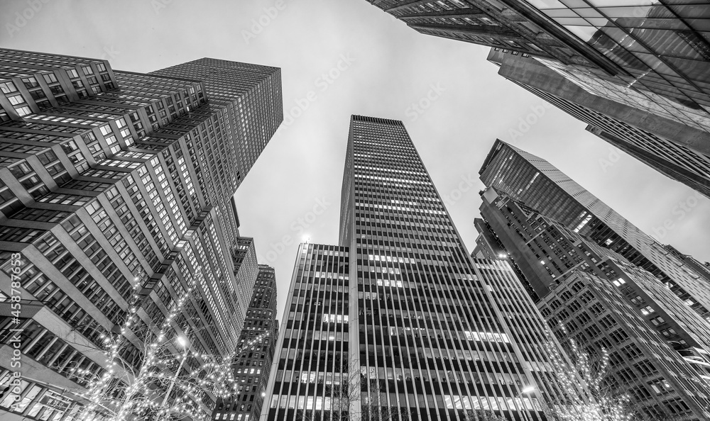 Fototapeta premium Exterior view of modern Midtown skyscrapers from the street at night - New York City.