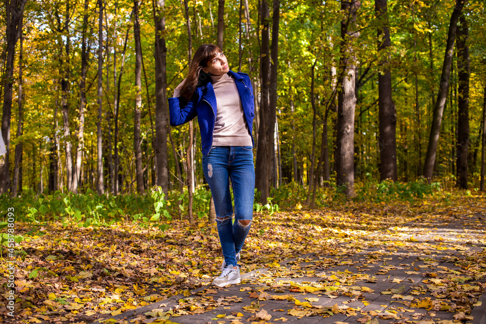 young beautiful womanin autumn park in sun shines on yellow trees background young beautiful womanin autumn park in sun shines on yellow trees background