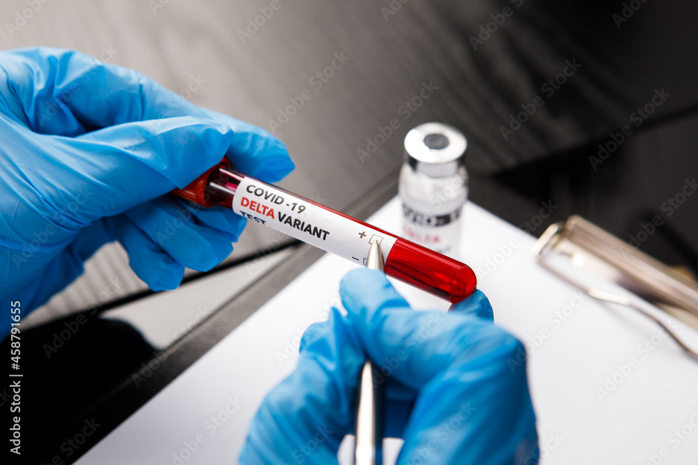covid 19 delta Variant vaccine and test blood in hand on table background. vaccination against coronavirus covid 19 delta Variant vaccine and test blood in hand on table background. vaccination against coronavirus