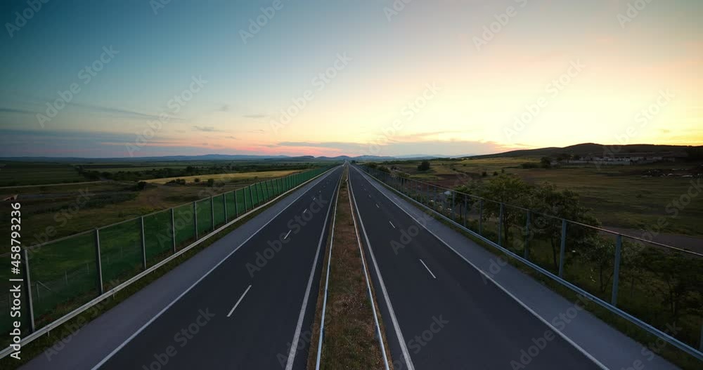 Aerial sunset view of driving on open highway road Aerial sunset view of driving on open highway road