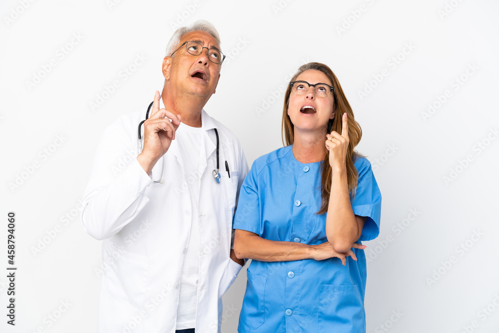Middle age doctor and nurse isolated on white background thinking an idea pointing the finger up Middle age doctor and nurse isolated on white background thinking an idea pointing the finger up