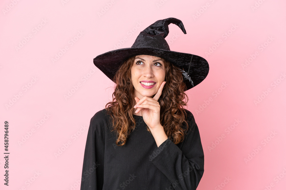 Fototapeta premium Young caucasian woman celebrating halloween isolated on pink background thinking an idea while looking up