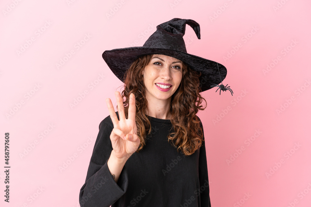 Young caucasian woman celebrating halloween isolated on pink background happy and counting three with fingers