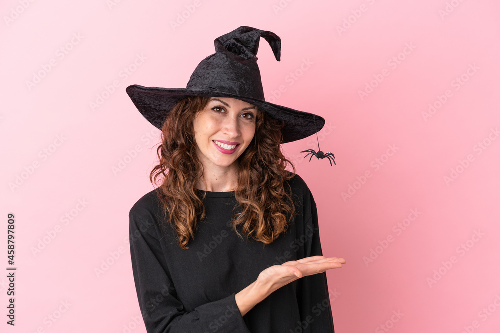 Young caucasian woman celebrating halloween isolated on pink background presenting an idea while looking smiling towards Young caucasian woman celebrating halloween isolated on pink background presenting an idea while looking smiling towards