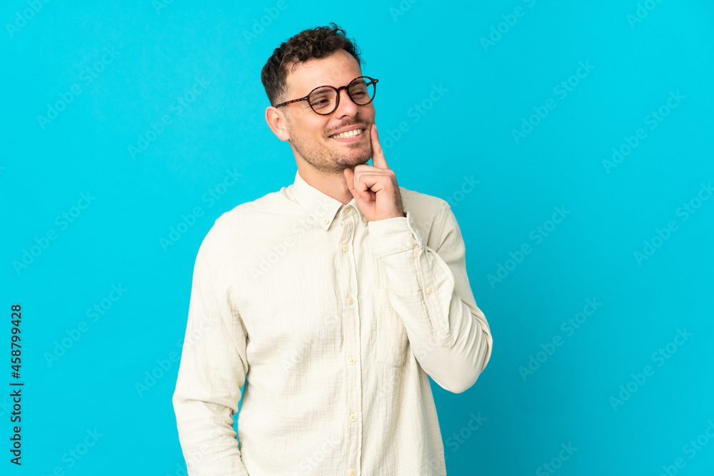 Young caucasian handsome man isolated on blue background thinking an idea while looking up Young caucasian handsome man isolated on blue background thinking an idea while looking up