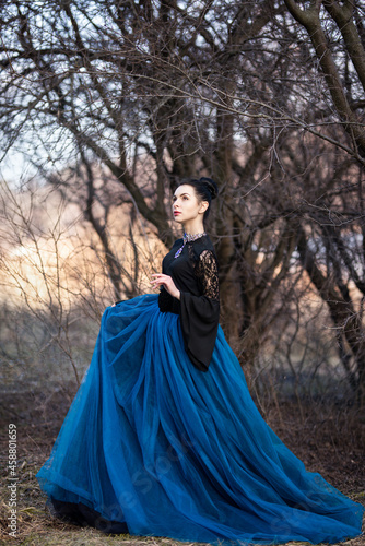 brunette in a blue dress in a winter forest