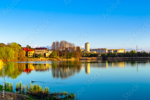 A wide blue lake and residential buildings on the far shore