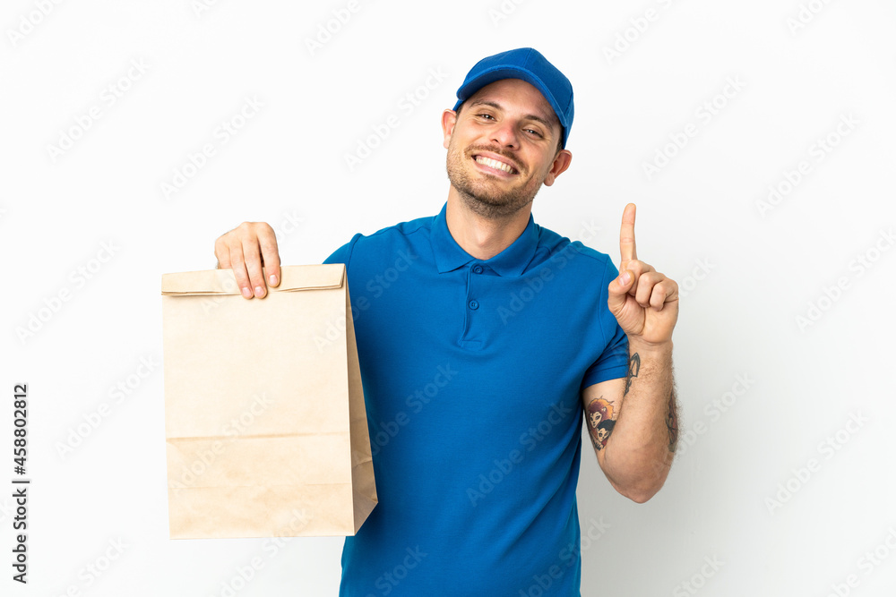 Brazilian taking a bag of takeaway food isolated on white background showing and lifting a finger in sign of the best Brazilian taking a bag of takeaway food isolated on white background showing and lifting a finger in sign of the best