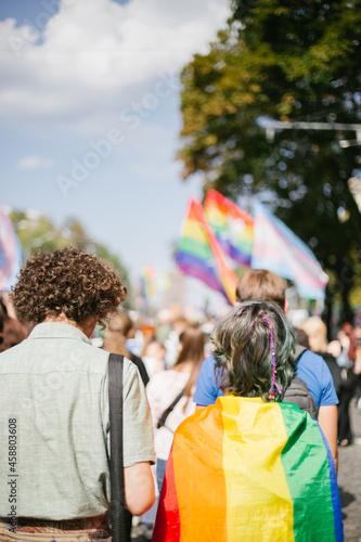 couple covered with lgbt flag in a crowd of people 