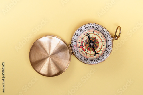 compass on yellow background close up with copy space
