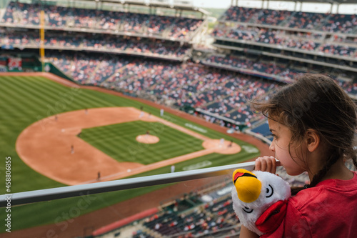little girl watching baseball game from the stands photo