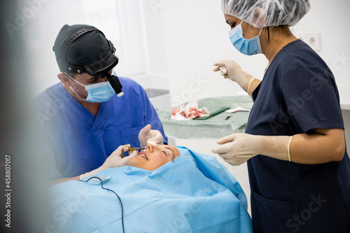 Surgeon sutures the eyelid after plastic surgery operation