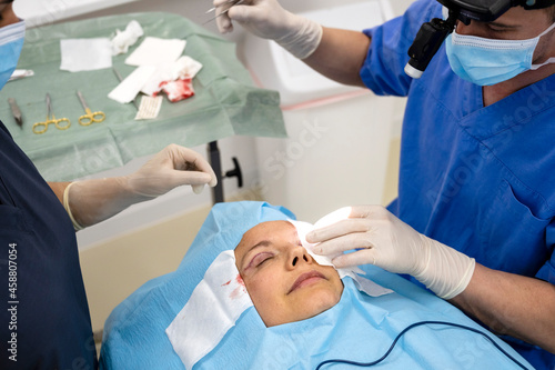 Surgeons performing eyelid surgery to anonymous patient photo