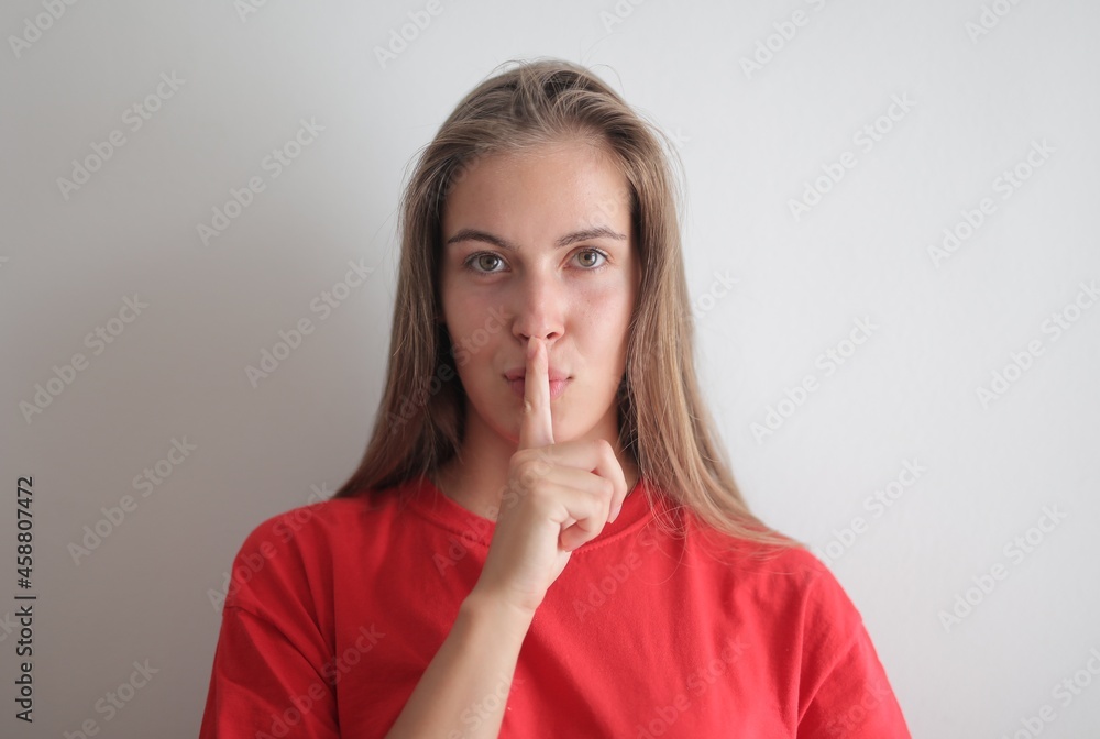 portrait of young woman with silence gesture portrait of young woman with silence gesture