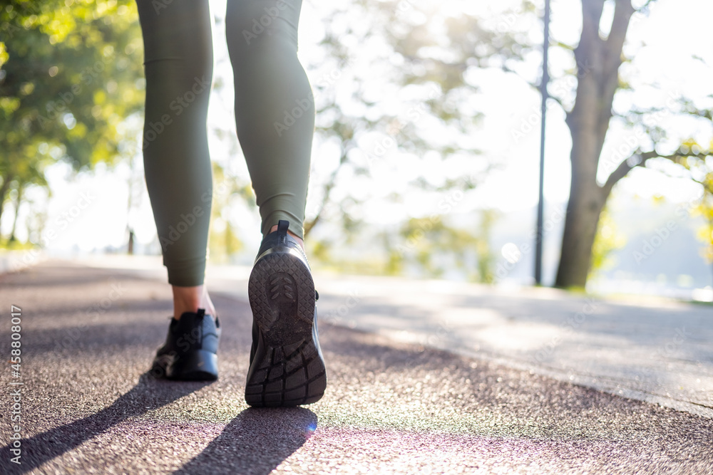 close up woman legs in sport sneakers running in park on sunrise time. Healthy fitness lifestyle close up woman legs in sport sneakers running in park on sunrise time. Healthy fitness lifestyle