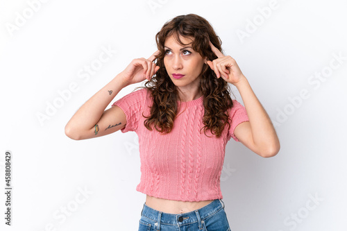 Young woman with curly hair isolated on white background having doubts and thinking