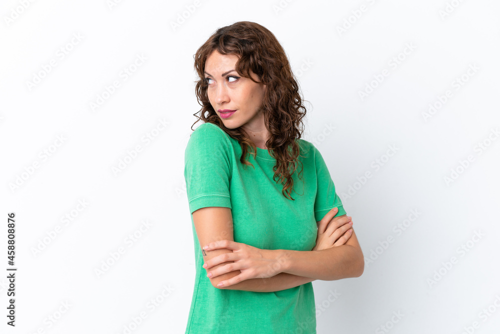 Young woman with curly hair isolated on white background keeping the arms crossed Young woman with curly hair isolated on white background keeping the arms crossed