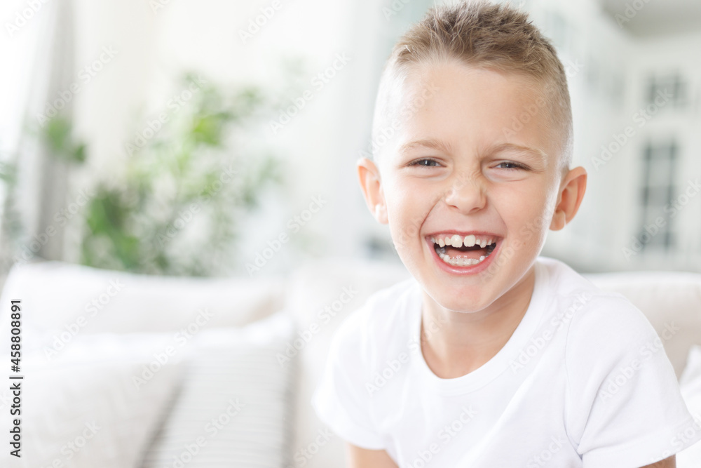 Portrait of laughing happy handsome boy, joyful child, little cheerful kid smiling on home background, copy space Portrait of laughing happy handsome boy, joyful child, little cheerful kid smiling on home background, copy space