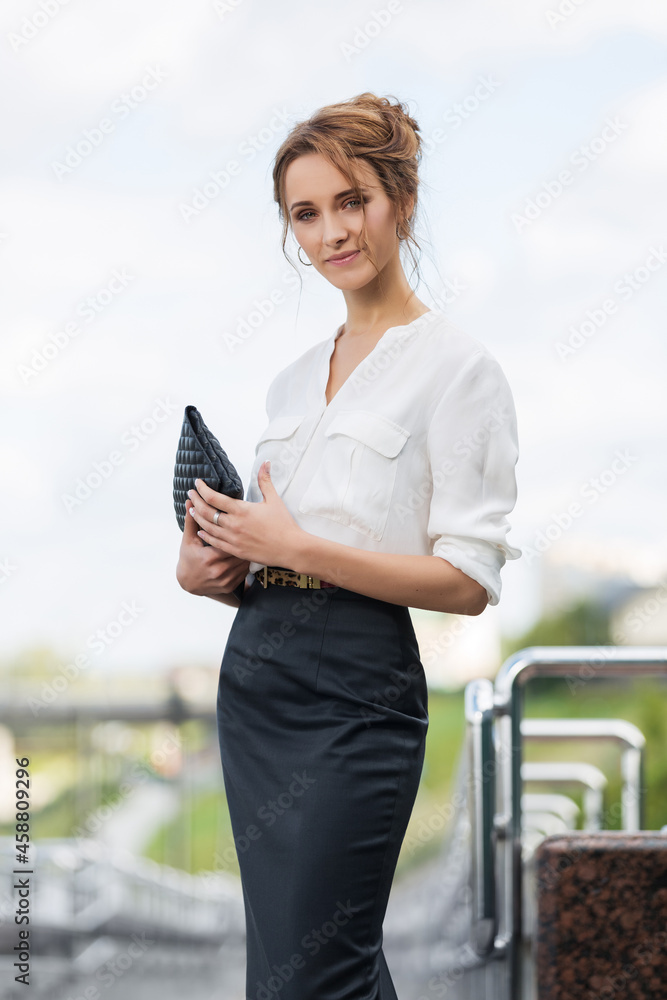 Young fashion business woman in white shirt and pencil skirt with clutch  bag Stock-Foto | Adobe Stock