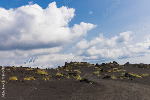 Volcanic-lunar landscape in Kamchatka  rocks from volcanic rocks against the background of a blue sky with clouds. Klyuchevskaya group of volcanoes.