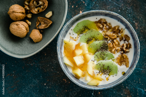 Healthy breakfast of muesli, kiwi, mango, honey and nuts with kefir yogurt and chia Seeds.