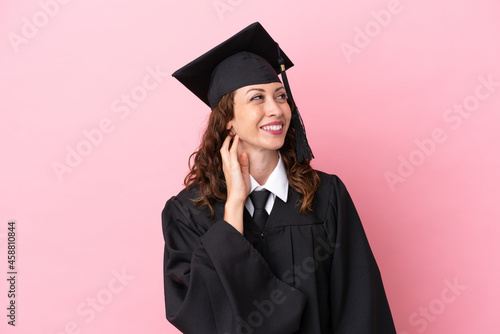 Young university graduate woman isolated on pink background thinking an idea