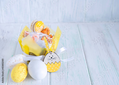 Easter cake beautifully decorated with icing, Easter eggs, rabbit. Easter composition on wooden background with place for text