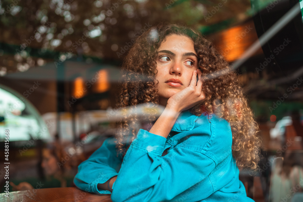 Obraz premium curly haired girl looking through the window