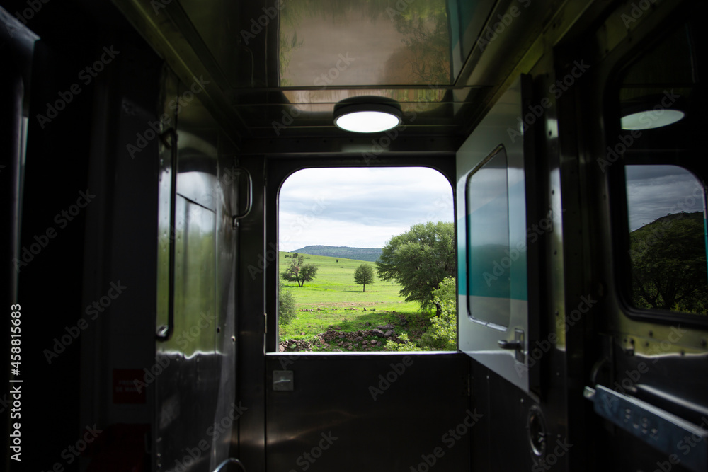 Puerta de tren abierta con vista al campo