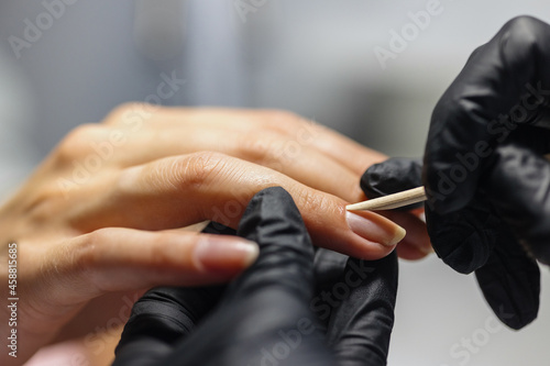the process of manicure in a studio or beauty salon for women. a manicure and pedicure master makes nails with a gel varnish coating for his client. hands and nails skin and nail care. aesthetics and © MyJuly