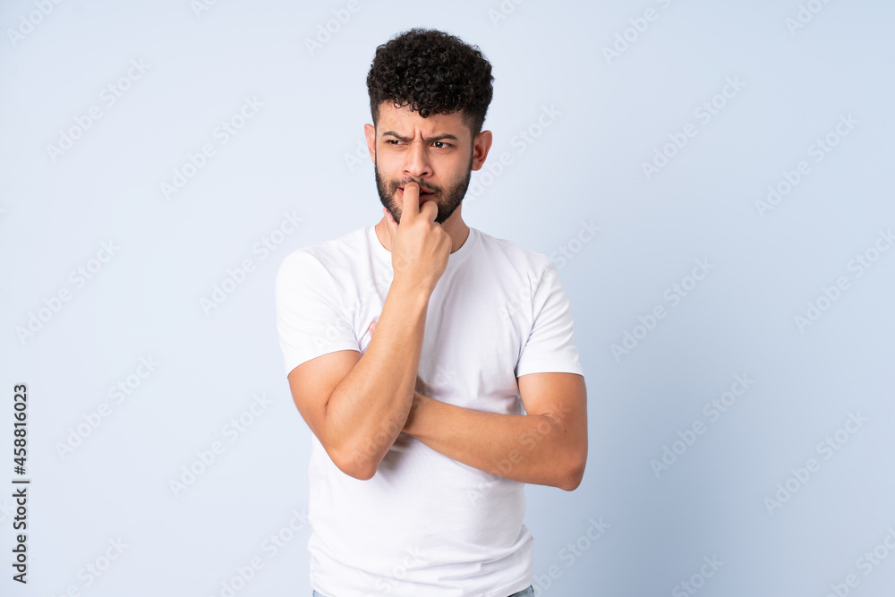 Young Moroccan man isolated on blue background nervous and scared Young Moroccan man isolated on blue background nervous and scared