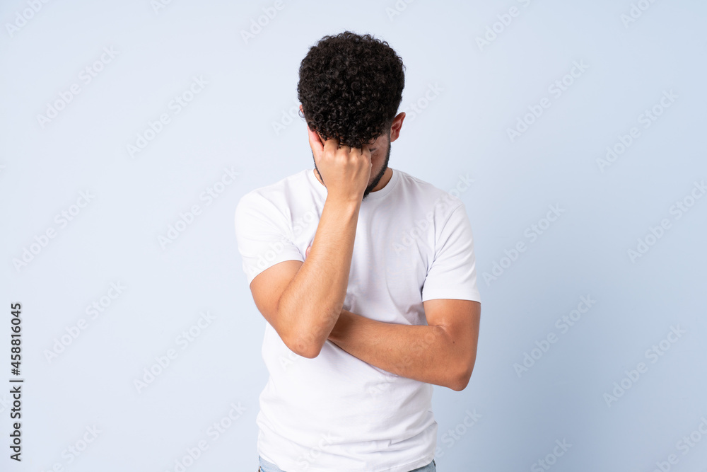 Young Moroccan man isolated on blue background with headache Young Moroccan man isolated on blue background with headache