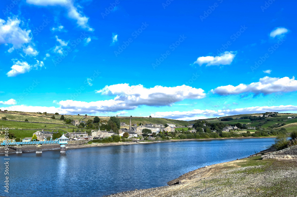 View across, Leeming Reservoir, on a summers day, with old cottages in the distance in, Leeming, Keighley, UK