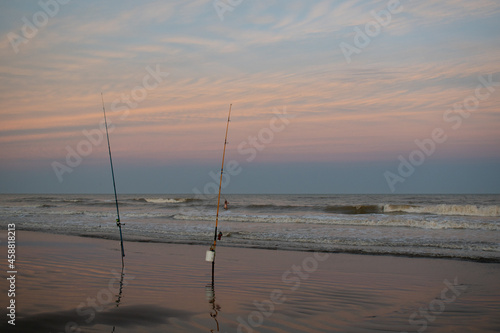 Pesca con cañas durante el atardecer en la playa