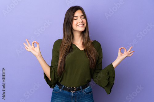 Teenager Brazilian girl over isolated purple background in zen pose