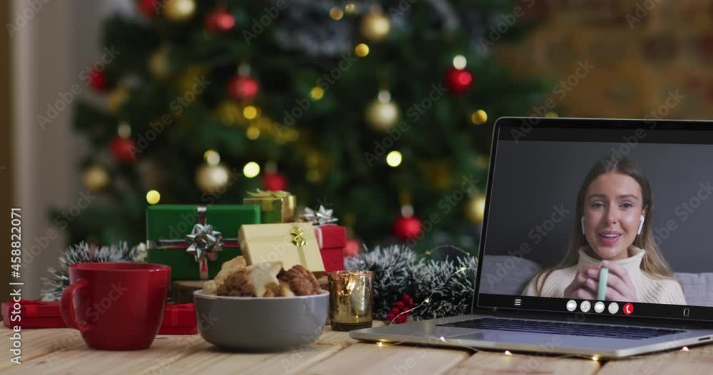Happy caucasian woman on video call on laptop, with christmas decorations and tree Happy caucasian woman on video call on laptop, with christmas decorations and tree
