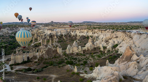 Hot Air balloons flying tour over Mountains landscape geological rock formation in autumn during sunrise in Cappadocia, Goreme National Park, Turkey nature background