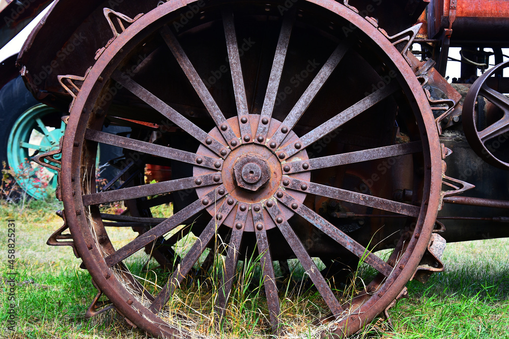 An image of an old rusted metal tractor tire on vintage farming equipment. 