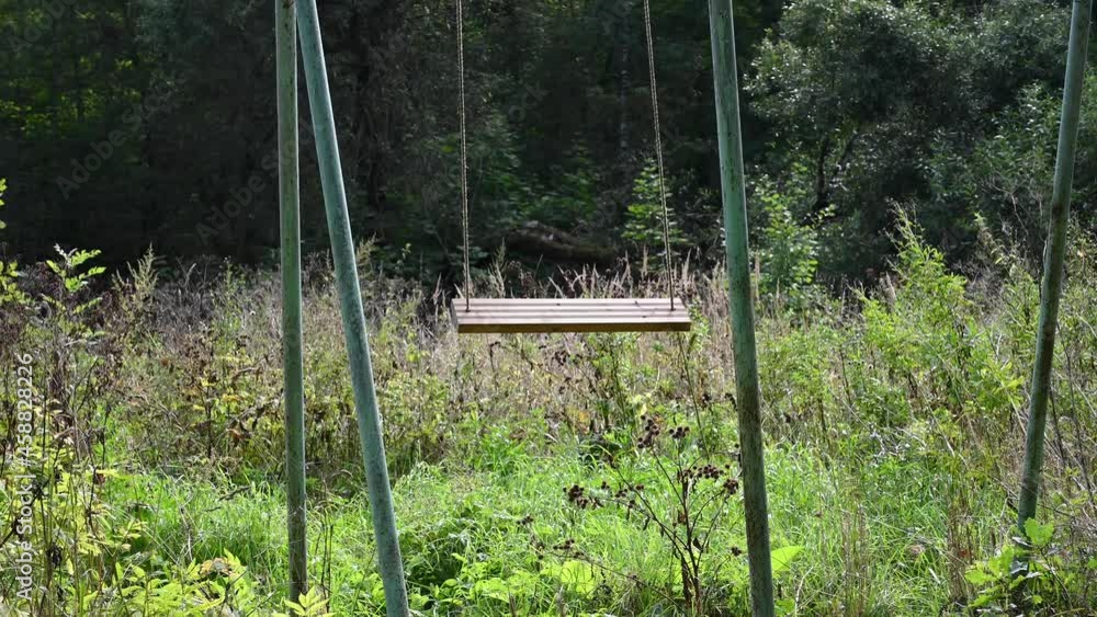 An empty abandoned swing in the forest. The concept of loneliness and time. Video. High quality 4k footage An empty abandoned swing in the forest. The concept of loneliness and time. Video. High quality 4k footage