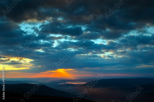 bright sunrise in the mountains with blue sky © mikhailgrytsiv