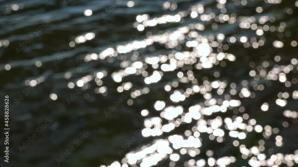 Vidéo Stock Bokeh sun glare reflected from the water surface in sunny ...