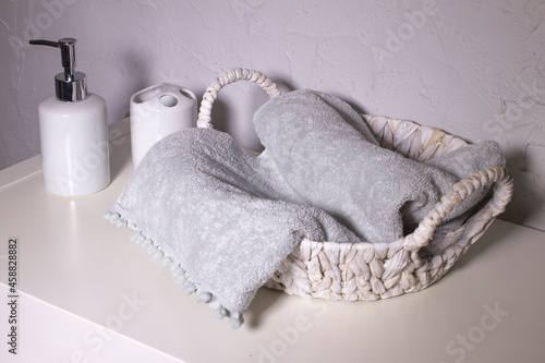 gray towel and liquid soap dispenser in the bathroom photo