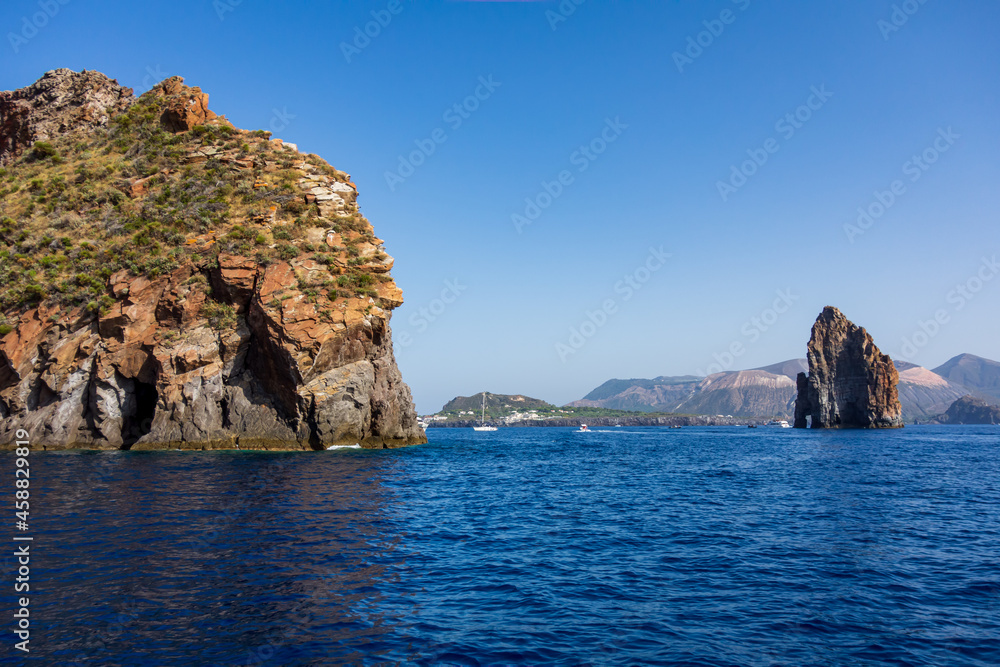 Lipari island (Aeolian archipelago), Messina, Sicily, Italy: view of the stack rocks with the island of Vulcano in the background.