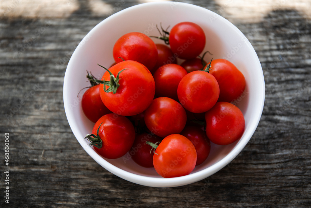 cherry tomatoes in a bowl on wooden table cherry tomatoes in a bowl on wooden table