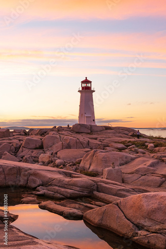 A lighthouse on a rocky cliff at dusk