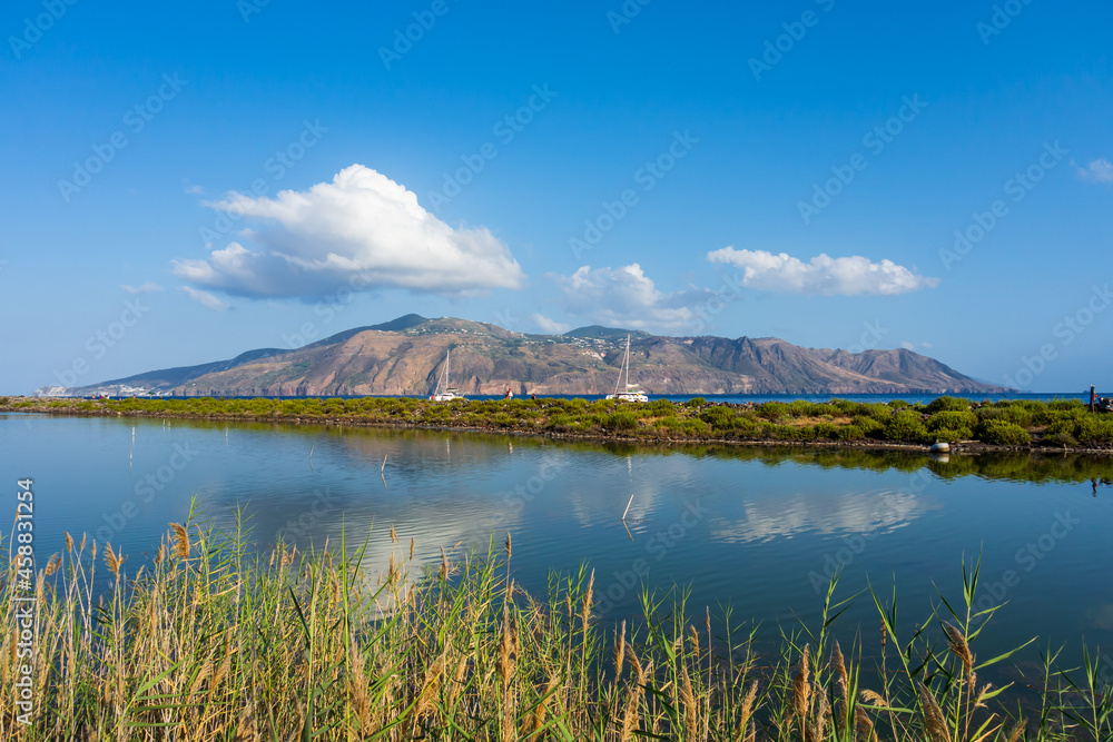 Salina island (Aeolian archipelago), Messina, Sicily, Italy, 08.16.2021: view of the salt lake in Punta Lingua with  Lipari island in the background.