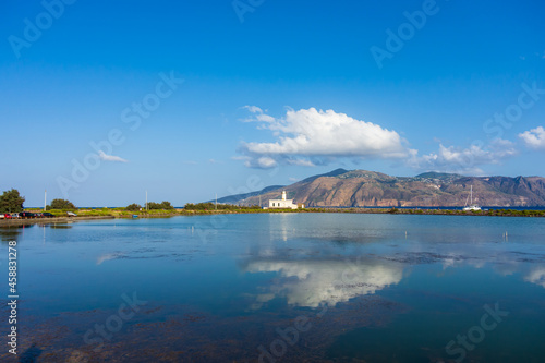 Salina island (Aeolian archipelago), Messina, Sicily, Italy, 08.17.2021: view of the salt lake with the white lighthouse in the background in Punta Lingua.