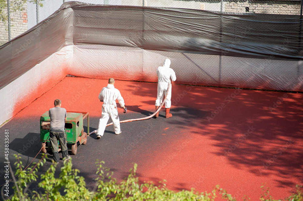 Liquid rubber coating process. A worker dressing security suit spraying