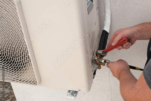 the worker installing and connecting a new air conditioner unit