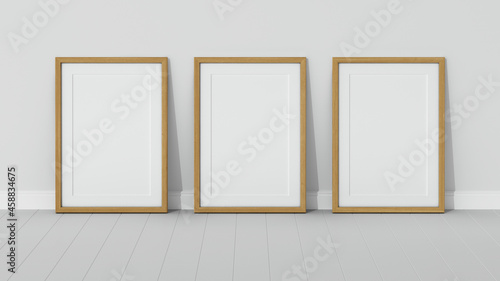 Three wooden frames on wooden floor with a white wall. Empty interior. 3D render vertical wooden frame mock up. White parquet. 3D illustrations. 3D design interior. Triptych. Passe partout frame.